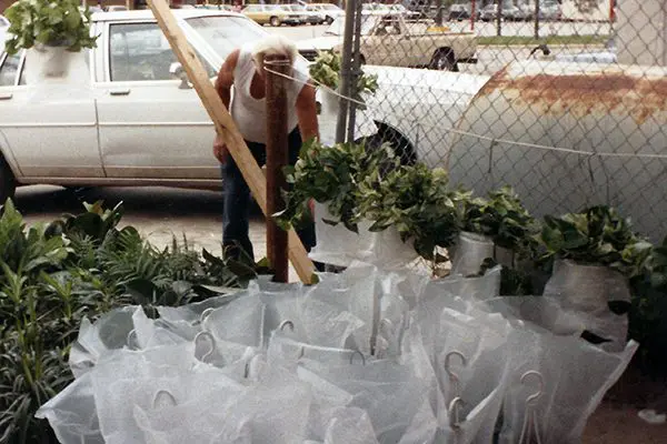 A man standing next to some bags of paper