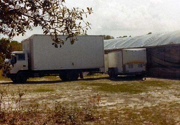 A trailer truck parked in front of a building.